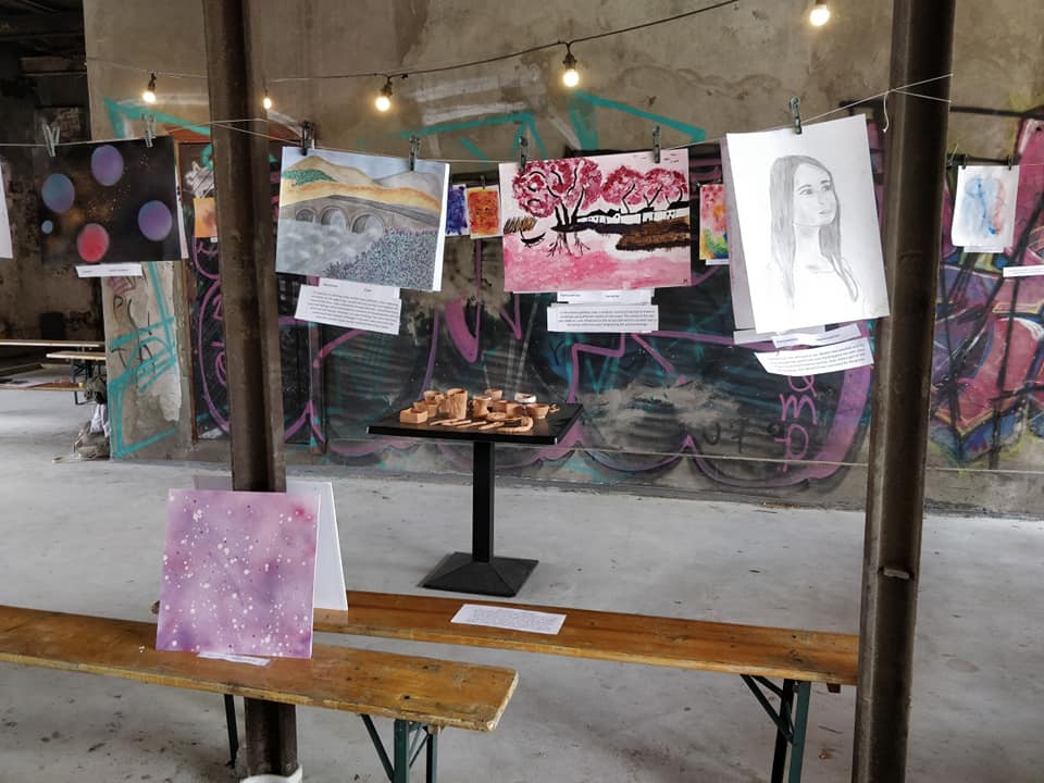 Black Canvas final exhibition — participants' artwork hung in a raw industrial space